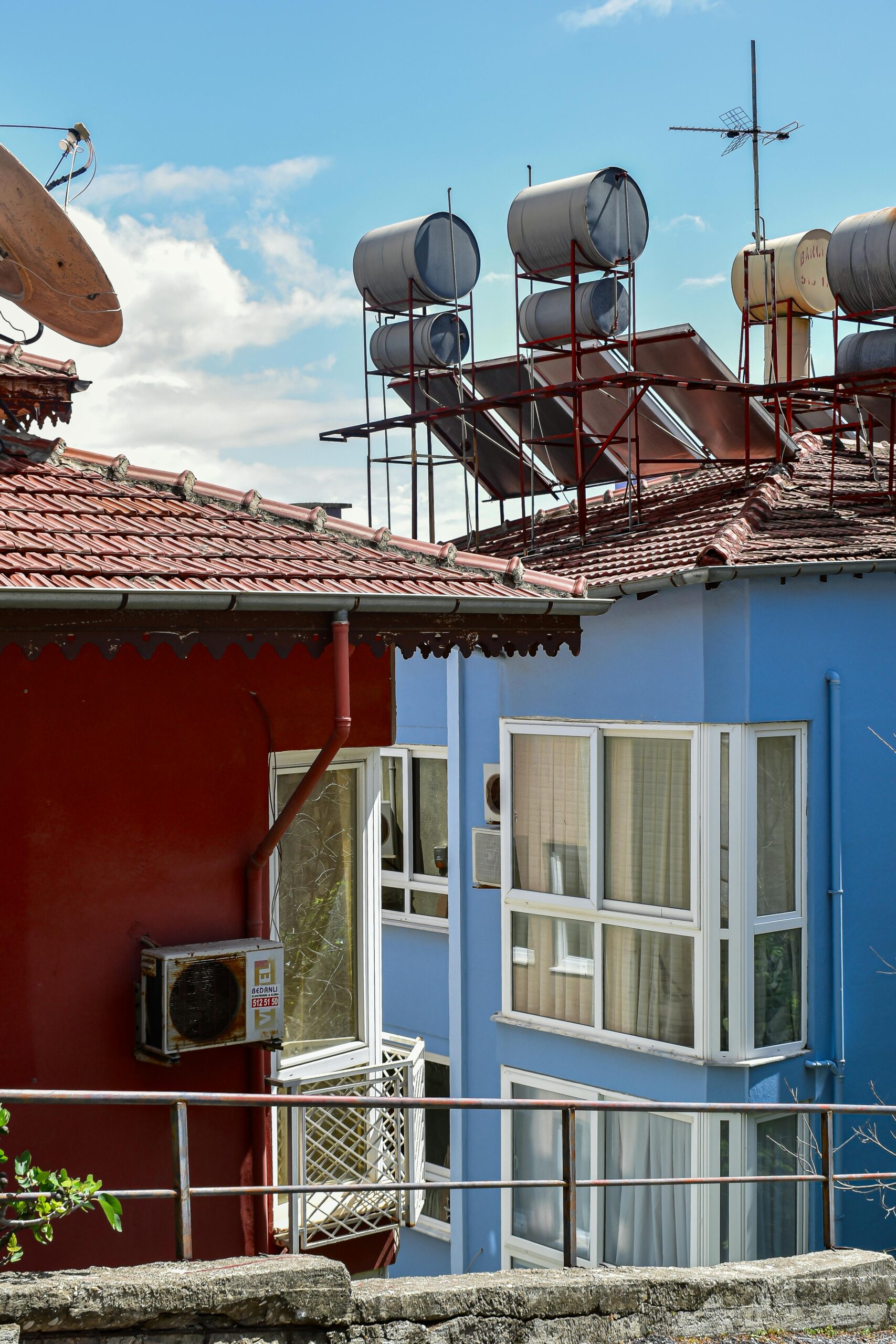 Colorful rooftops with solar water heaters in sunny urban setting. Ideal for energy or architecture themes.
