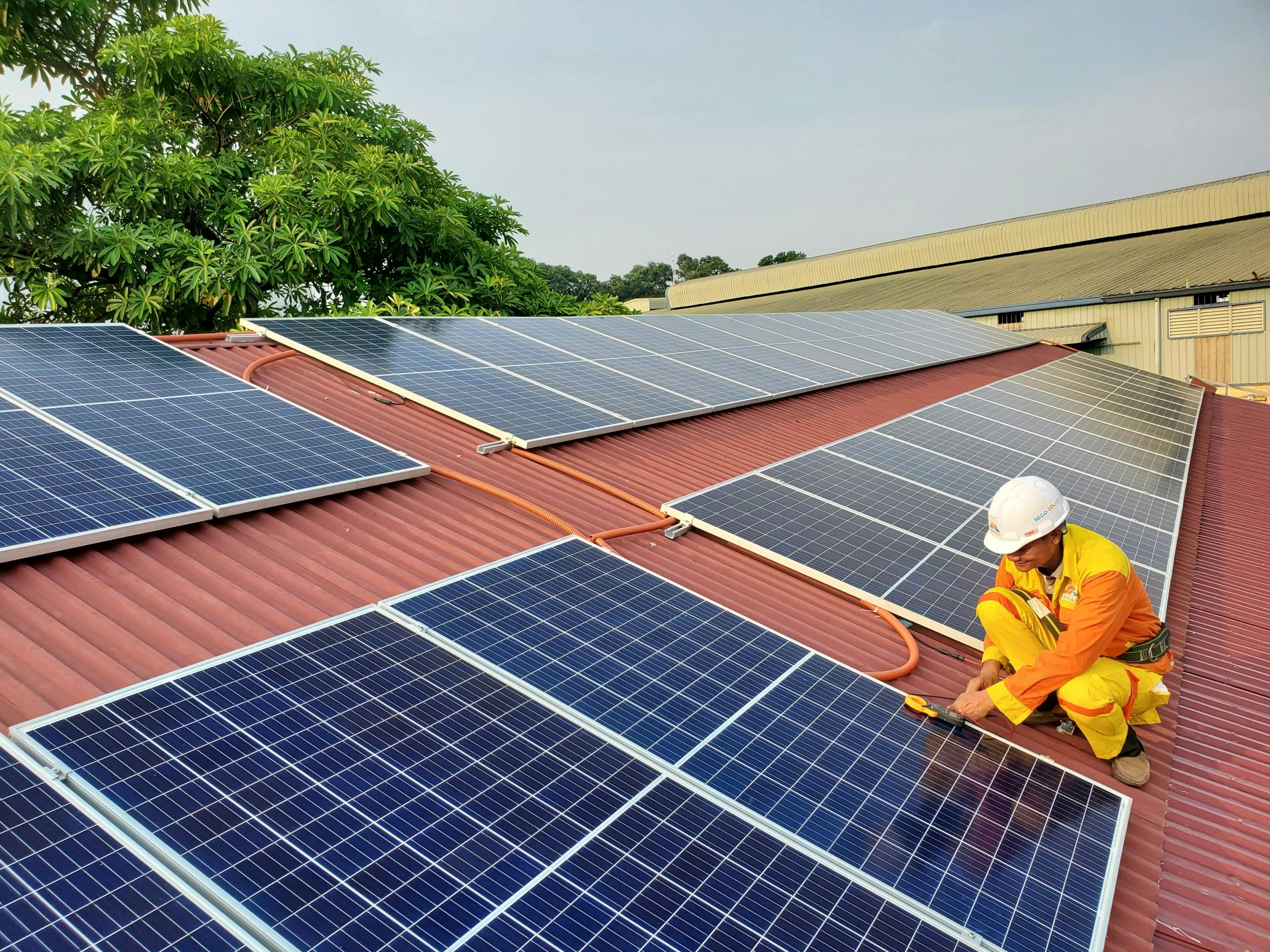 A solar technician performs maintenance on rooftop solar panels enhancing energy efficiency.